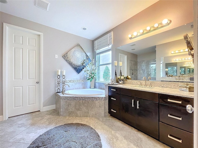 bathroom featuring baseboards, visible vents, a garden tub, a tile shower, and vanity