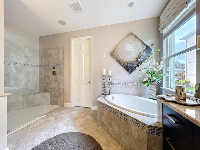 bathroom with visible vents, vanity, baseboards, a bath, and walk in shower