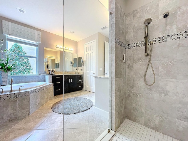 bathroom with visible vents, vanity, a bath, and walk in shower