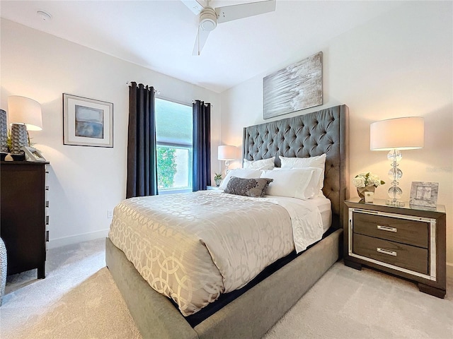 bedroom with ceiling fan, baseboards, and light colored carpet