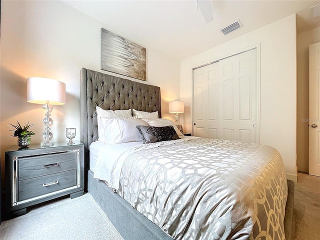 bedroom with carpet, visible vents, ceiling fan, and a closet