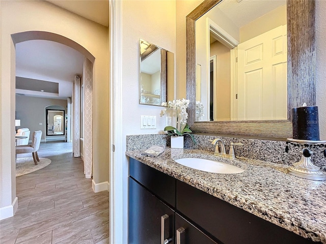 bathroom with baseboards, wood finished floors, and vanity