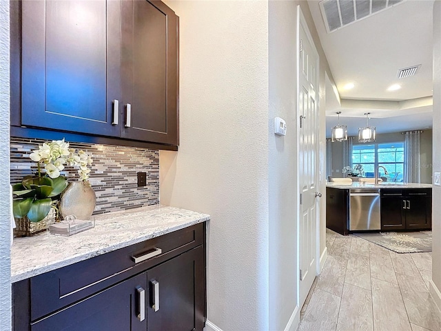 kitchen with dishwasher, a sink, visible vents, and decorative backsplash