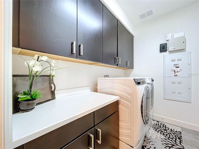 clothes washing area featuring visible vents, cabinet space, washer and clothes dryer, and baseboards