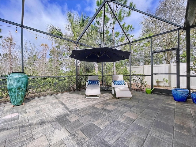 view of patio with a lanai and fence