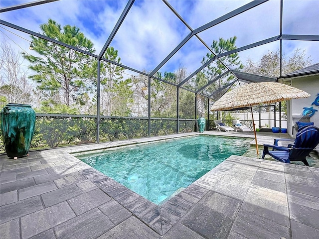 outdoor pool featuring glass enclosure and a patio area