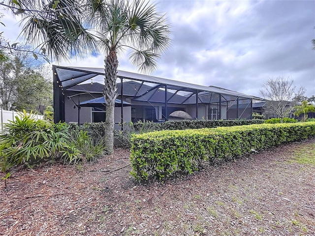 rear view of property with a lanai and stucco siding