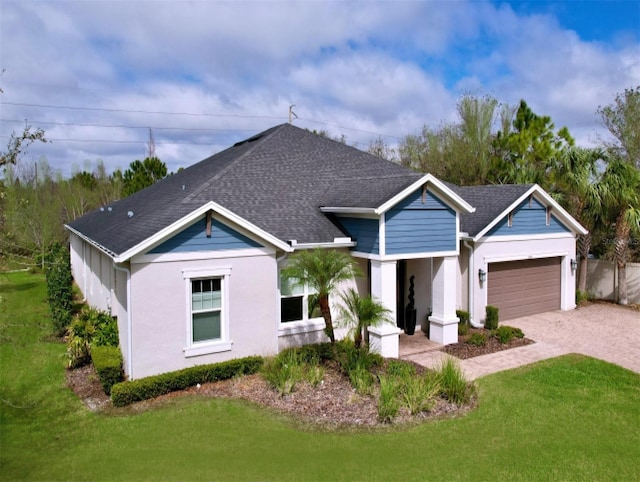 view of front of home with an attached garage, roof with shingles, decorative driveway, and a front yard