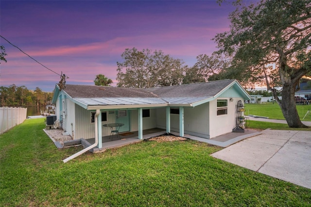 10501 Bridgewood Dr, Riverview, FL 33578 - back house at dusk featuring a lawn and central air condition unit