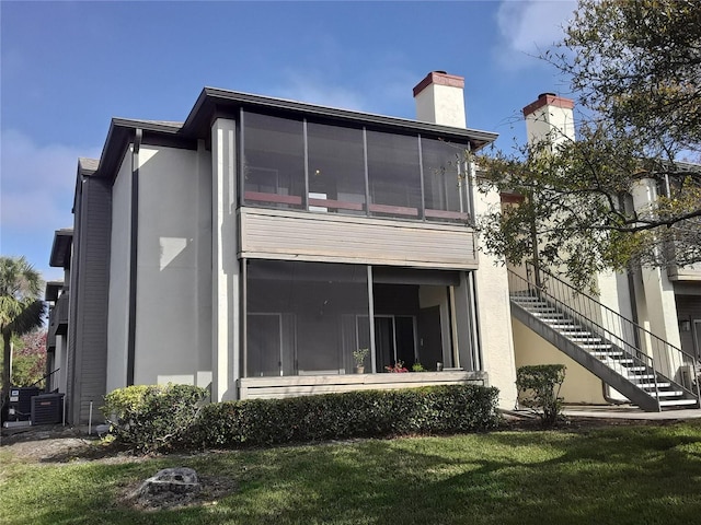 back of property featuring a yard and a sunroom