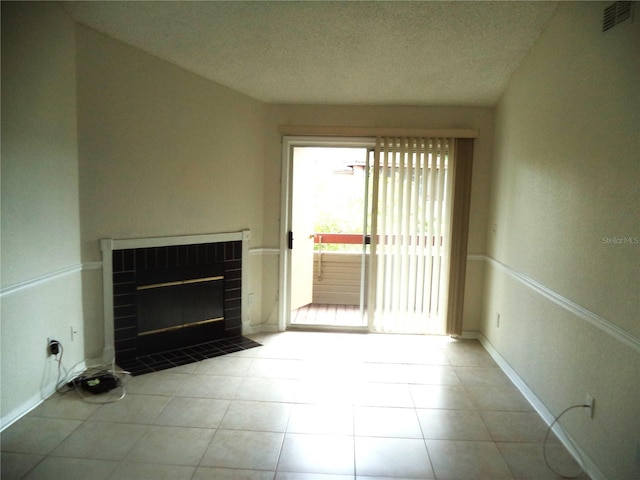 unfurnished living room featuring light tile patterned floors, a textured ceiling, and a fireplace