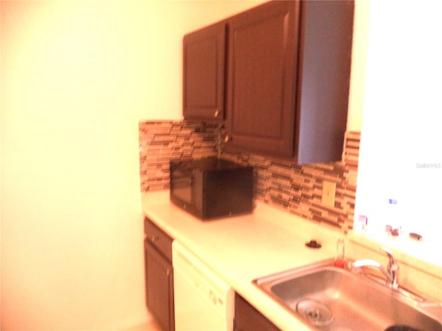 kitchen with white dishwasher, sink, and decorative backsplash