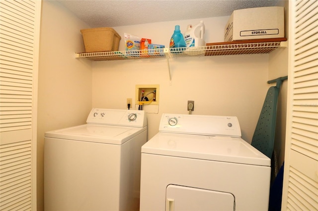 washroom with washing machine and dryer and a textured ceiling