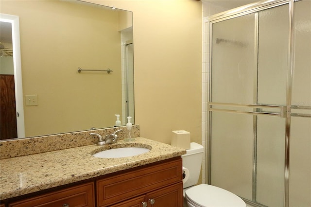 bathroom featuring vanity, toilet, and an enclosed shower