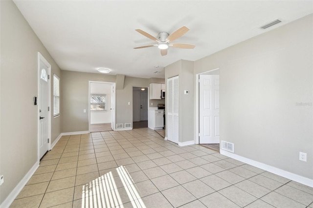 unfurnished living room with ceiling fan and light tile patterned flooring