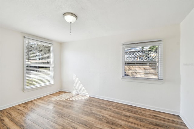 empty room with hardwood / wood-style floors and a textured ceiling