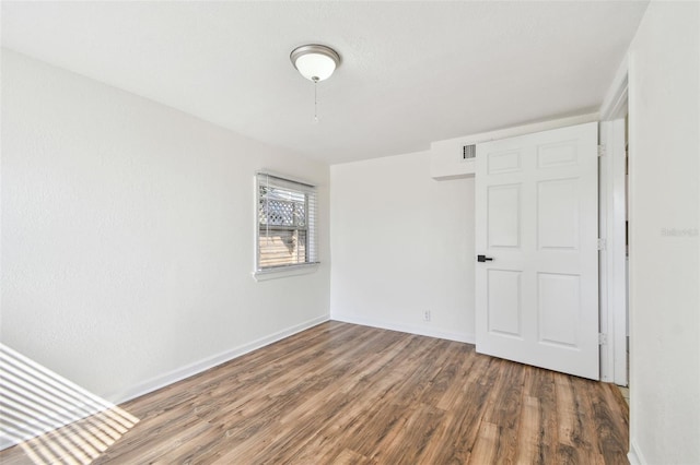 unfurnished bedroom with dark hardwood / wood-style flooring