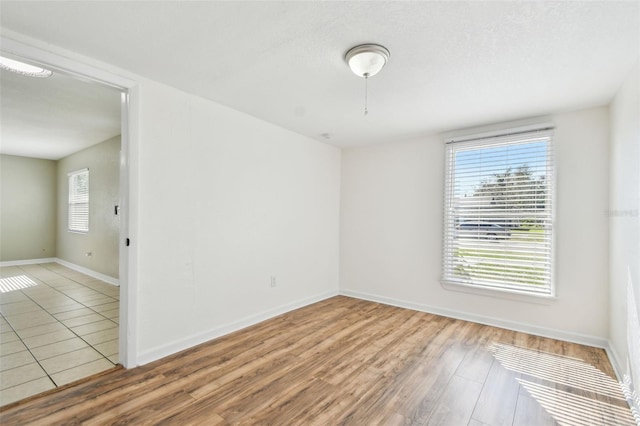 spare room featuring plenty of natural light and light hardwood / wood-style floors