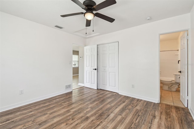 unfurnished bedroom featuring dark hardwood / wood-style flooring, a closet, ceiling fan, and ensuite bathroom