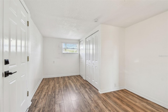 spare room with dark hardwood / wood-style floors and a textured ceiling