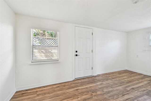 unfurnished room with hardwood / wood-style floors and a healthy amount of sunlight