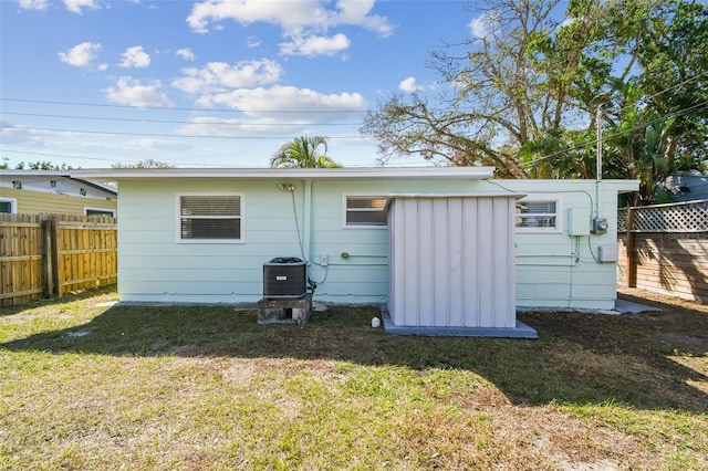 back of property featuring a yard and central air condition unit