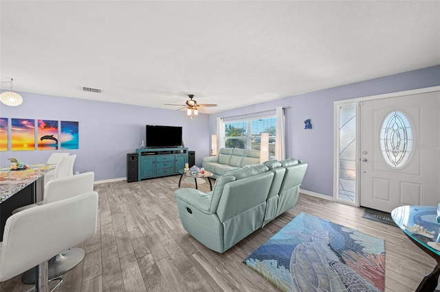 9911 Antilles Dr, Seminole, FL 33776 - living area with visible vents, light wood-style flooring, and baseboards