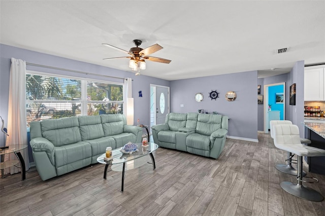 9911 Antilles Dr, Seminole, FL 33776 - living area featuring light wood-style floors, ceiling fan, visible vents, and baseboards