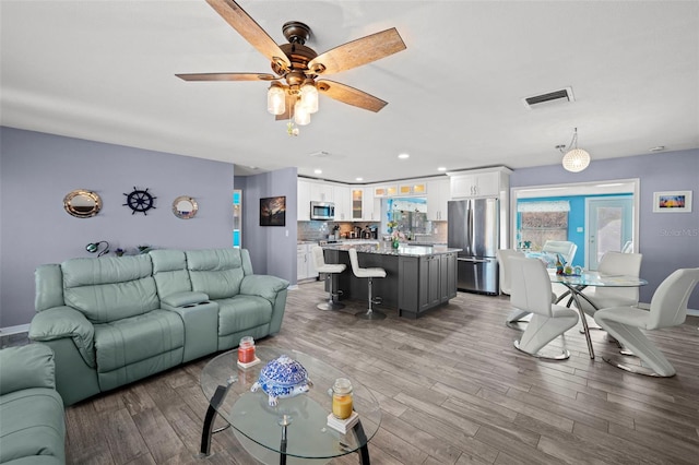 9911 Antilles Dr, Seminole, FL 33776 - living area with a ceiling fan, recessed lighting, visible vents, and wood finished floors