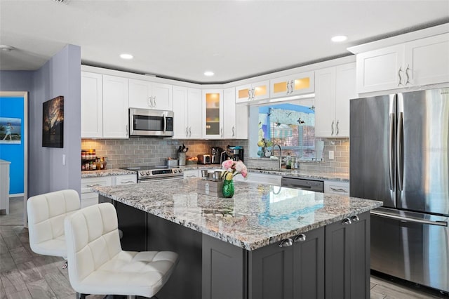 9911 Antilles Dr, Seminole, FL 33776 - kitchen with glass insert cabinets, white cabinetry, appliances with stainless steel finishes, and a center island