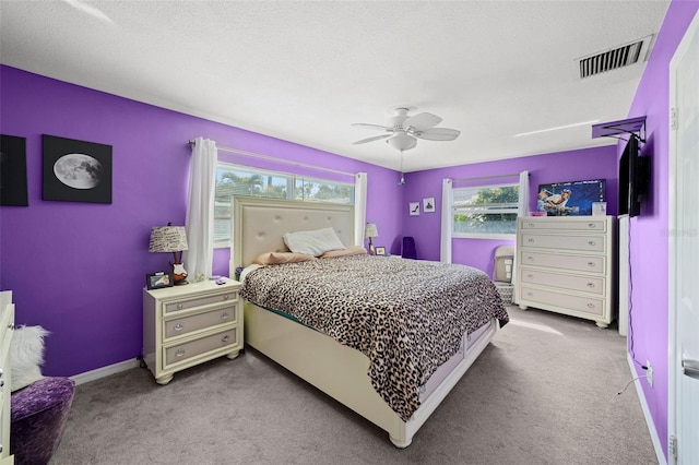 9911 Antilles Dr, Seminole, FL 33776 - bedroom featuring light carpet, baseboards, visible vents, a ceiling fan, and a textured ceiling