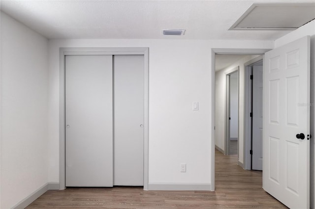 unfurnished bedroom featuring light wood-type flooring and a closet