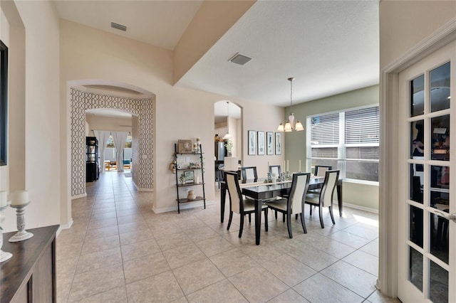 dining space with a notable chandelier, light tile patterned flooring, and plenty of natural light