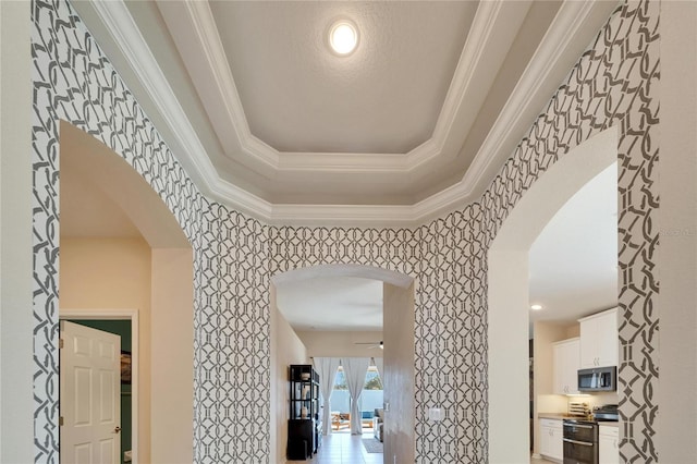 interior space with a raised ceiling and crown molding