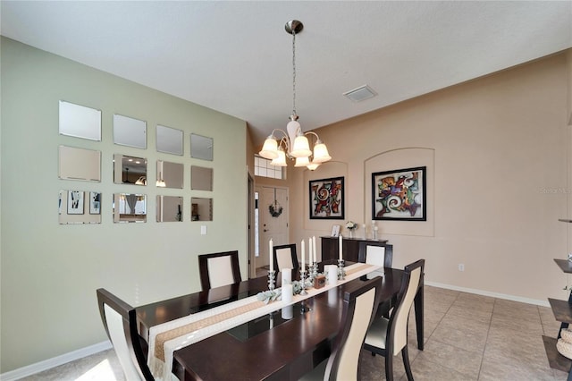 tiled dining area featuring an inviting chandelier