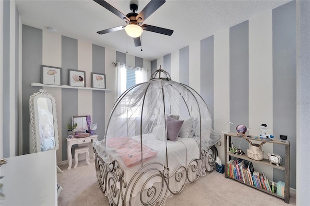 bedroom featuring a textured ceiling, light carpet, and ceiling fan