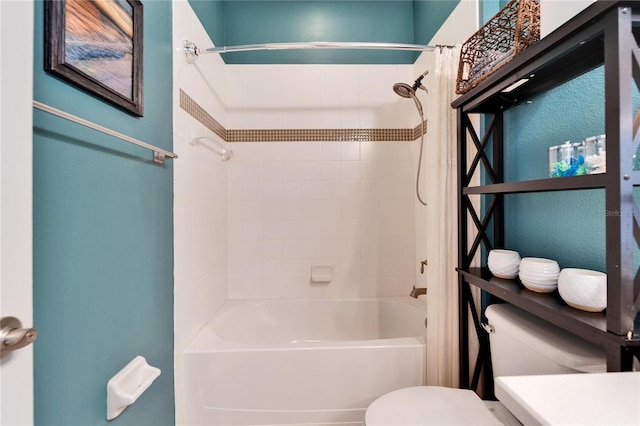 bathroom featuring tiled shower / bath and toilet