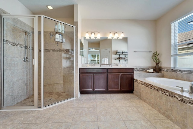 bathroom featuring tile patterned flooring, vanity, plus walk in shower, and a healthy amount of sunlight