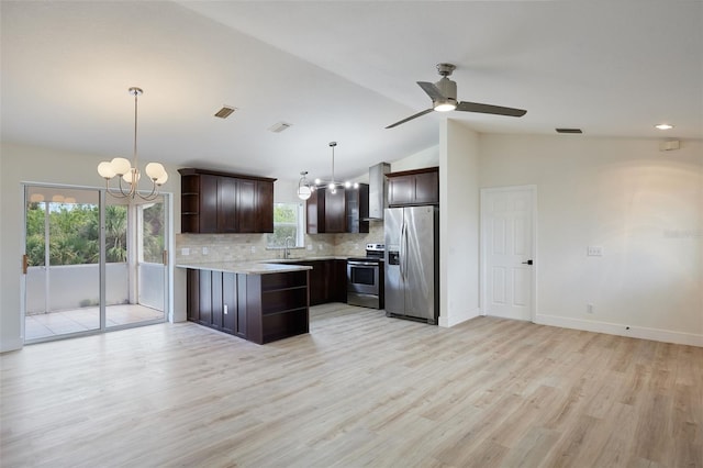 kitchen featuring wall chimney exhaust hood, dark brown cabinets, hanging light fixtures, appliances with stainless steel finishes, and backsplash