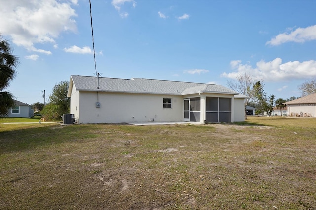 rear view of house with a yard, a sunroom, and central air condition unit