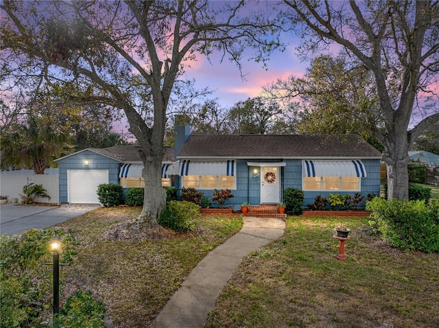 ranch-style house featuring a garage and a yard