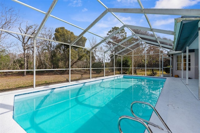 view of swimming pool featuring a patio and a lanai