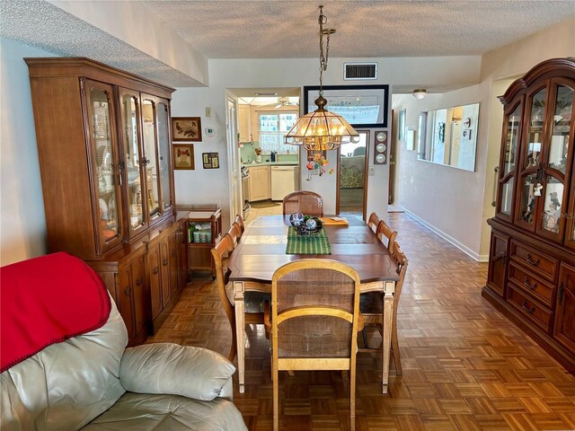 dining space featuring visible vents, a textured ceiling, and baseboards