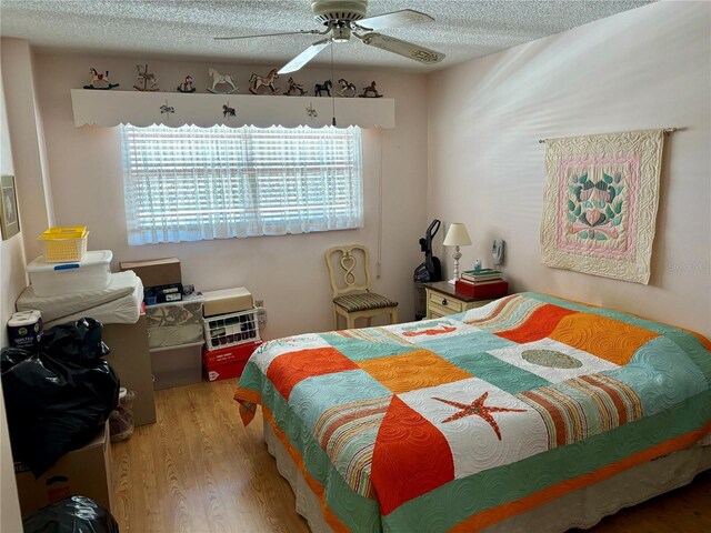 bedroom featuring a textured ceiling, wood finished floors, and a ceiling fan