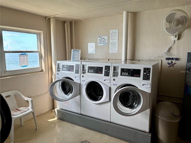 community laundry room featuring a textured wall and separate washer and dryer