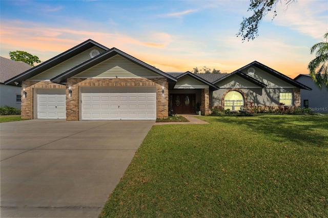 ranch-style house featuring a garage and a lawn