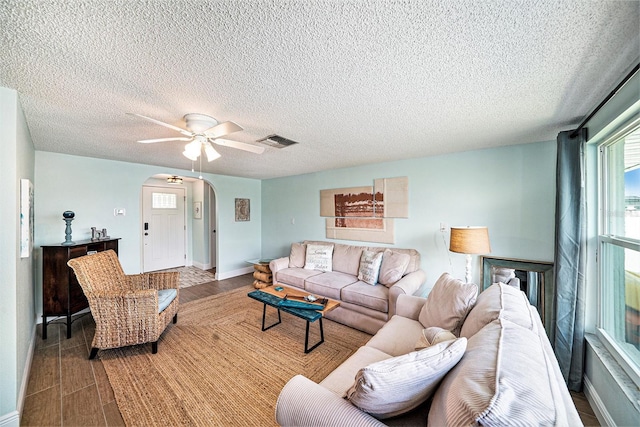 13614 Evelane Dr, Hudson, FL 34667 - living area with arched walkways, ceiling fan, a textured ceiling, wood finished floors, and baseboards