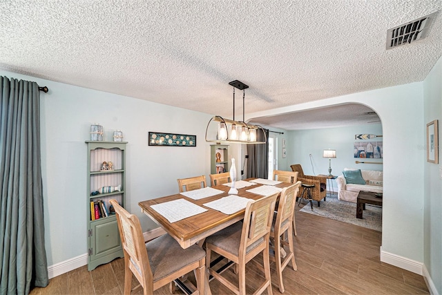 13614 Evelane Dr, Hudson, FL 34667 - dining space with light wood finished floors, arched walkways, a textured ceiling, and baseboards