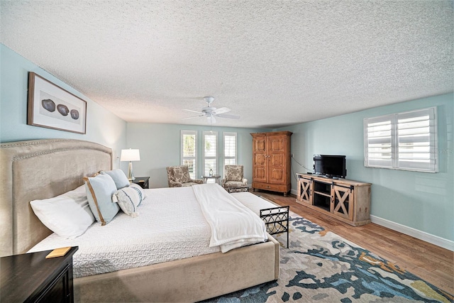 13614 Evelane Dr, Hudson, FL 34667 - bedroom featuring wood finished floors, multiple windows, baseboards, ceiling fan, and a textured ceiling