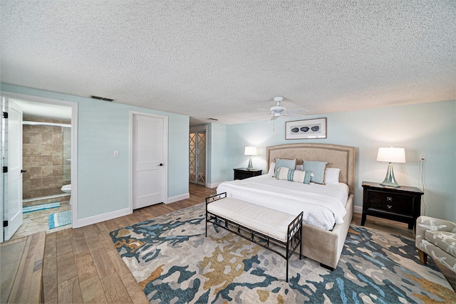 13614 Evelane Dr, Hudson, FL 34667 - bedroom featuring wood finished floors, a textured ceiling, baseboards, connected bathroom, and ceiling fan